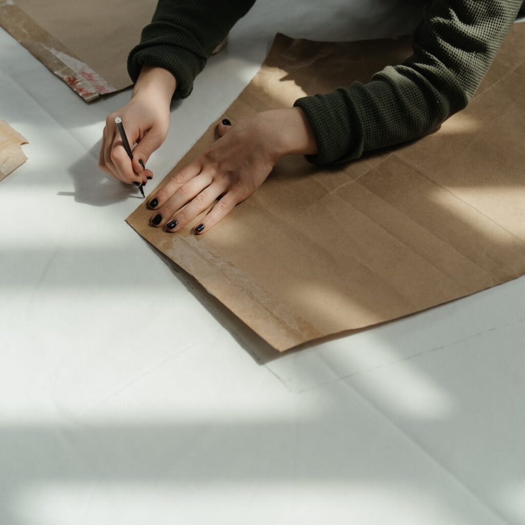 Person in Black and Gray Long Sleeve Shirt Holding Brown Wooden Board