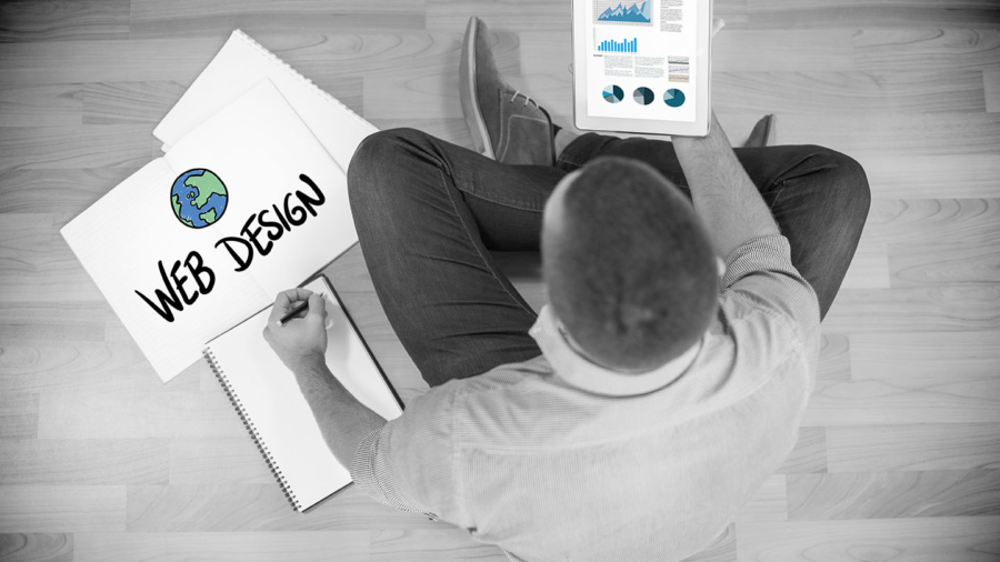 Business graphs against young creative businessman looking at tablet