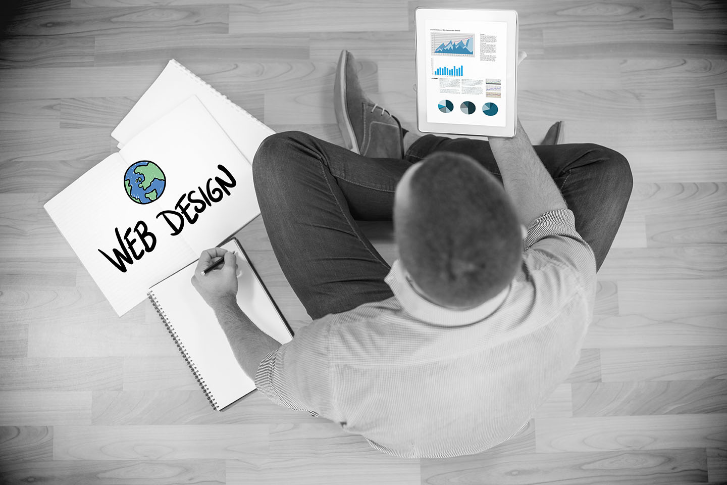 Business graphs against young creative businessman looking at tablet